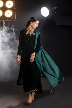 An emerald green velvet outfit with a cut-out embroidered neckline and sparkling embroidered trousers (included) is a striking and glamorous choice that combines rich color, intricate detailing, and a touch of sparkle.  Complete this ethereal look with this luxurious silk dupatta (sold separately) with sparkling sequin Henna Mehndi