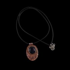 This one-of-a-kind handcrafted Copper fan necklace shimmers with black sparkle agate. It's accompanied by a sleek black cord and hangs at a length of 12 inches. Keep it looking its best with a soft cloth. Elegant Black Necklace With Adjustable Cord, Black Metal Amulet Necklace, Black Amulet Necklace With Large Pendant, Adjustable Black Amulet Necklace, Black Oval Pendant Necklace Spiritual Style, Black Oval Pendant Necklace With Spiritual Style, Copper Fan, Fan Necklace, Black Sparkle