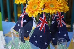 a vase filled with yellow flowers sitting on top of a blue tablecloth covered table