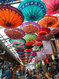 many colorful umbrellas are hanging from the ceiling