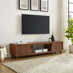 a flat screen tv mounted to the side of a wooden cabinet in a living room