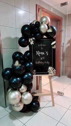 there is a sign that says welcome to rena's birthday with black and silver balloons