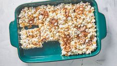 a green dish filled with popcorn and nuts