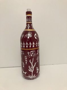 a red and white bottle with people on it sitting on a table next to a wall