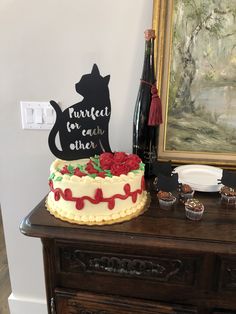 there is a cake that has been decorated with flowers and a cat sign on it