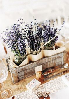 the table is set with lavenders and wine glasses