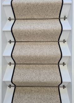 a carpeted staircase with white and black trim