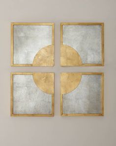 four square mirrors mounted to the wall with gold frames on each one side and an abstract design in the middle