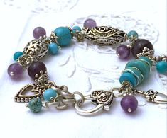 Embrace your joie de vivre with this playful gemstone bracelet, made with amethyst and turquoise howlite gemstone beads. It has lovely silver heart charm and many amethyst and turquoise dangles.  It will fit a wristsize of 5.9 up to 7.1 inches (15-18 cm.) A bracelet to love and cherish. Please note: As this piece of jewelry is also made of natural stone beads, colours and patterns of the stone beads may vary a little. Also please be aware that the colours may appear a little different, depending on your computer or mobile phone screen.  If you would like us to make the bracelet in a different size, just let us know by leaving us a message in the notes section. In that case we may be able to add or distract 1 or more beads, or add a piece of rolo chain, to make the bracelet fit your wrist. Jewelry Heart, Natural Stone Beads, Turquoise Howlite, Rolo Chain, Phone Screen, Heart Bracelet, Turquoise Gemstone, Heart Jewelry, Bohemian Jewelry