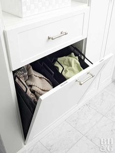 an open drawer with clothes in it on the counter top next to a tiled floor