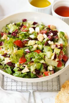 a white bowl filled with salad next to bread