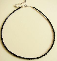 Black Beaded Choker Necklace, Seed Bead Necklace, Dainty Jewelry Simple yet elegant all black beaded choker with glass tiny seed beads. DESCRIPTION Made from 2mm glass seed beads and closes with a gold plated clasp and 2 inches adjustable chain. SIZE Necklace is 13 inches and can be adjusted up to 15 inches with a 2 inches extender chain. Please let me know if you would like a different length. WRAPPING - All ZafireniaDainty jewelry arrive gift wrapped in a cute bag or box ready for giving. SIZI Black Choker With Faceted Beads As Gift, Black Faceted Beads Choker As Gift, Black Beaded Choker For Jewelry Making, Black Beaded Choker As Gift, Adjustable Black Beaded Necklaces With Round Beads, Adjustable Black Choker With Colorful Beads, Adjustable Black Choker With Tiny Beads, Handmade Black Beaded Necklaces With Round Beads, Black Tiny Beads Choker Necklace