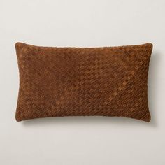 a brown woven pillow sitting on top of a white wall