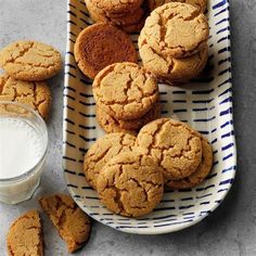 some cookies are on a plate next to a glass of milk