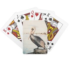 a bird sitting on top of a rock in the water playing cards with two hands