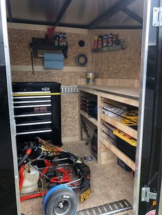 the inside of a trailer with tools and other items in it's storage area