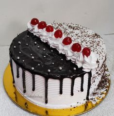 a black and white cake with cherries on top