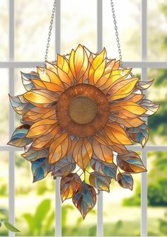 a stained glass sunflower hanging from a window