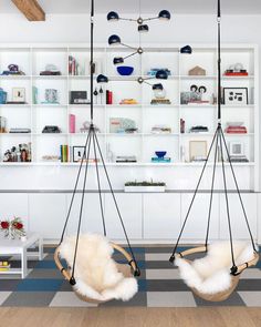 two hanging chairs in the middle of a room