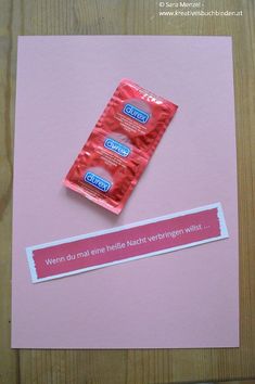 two packets of chewing gum sitting on top of a pink card