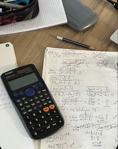 a calculator sitting on top of a table next to papers