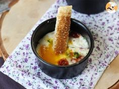 a bowl of soup with bread sticks sticking out of the side on a cloth napkin