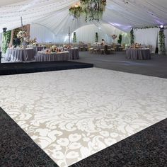 a large white dance floor with chandeliers and tables set up for an event