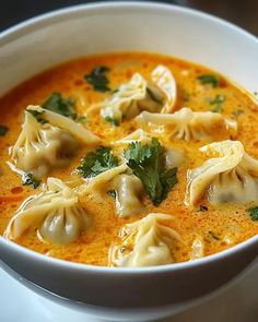 a white bowl filled with soup and dumplings