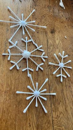 white snowflakes are arranged on a wooden table