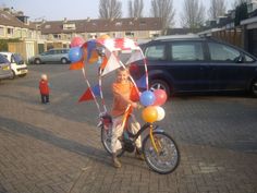 a child on a bike with balloons attached to it