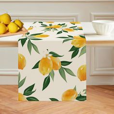 a table topped with lemons on top of a wooden table next to a bowl of fruit