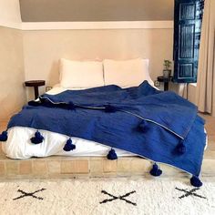 a bed with blue blankets and white pillows