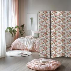 a room divider with pink and white flowers on it, next to a bed