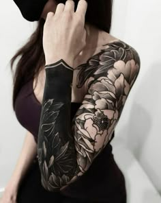 a woman with black and white tattoos on her arm