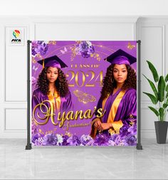 a purple graduation banner with two women in gowns and flowers on the front, next to a potted plant