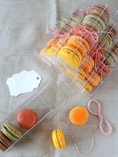 an assortment of macaroons and pastries in plastic containers