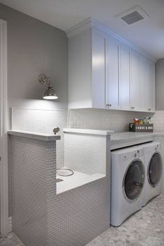 a washer and dryer in a white laundry room with gray tile flooring