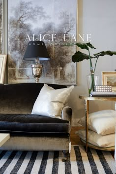 a black and white striped rug in front of a couch with a lamp on it