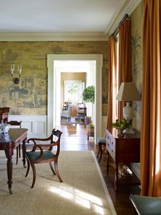 a living room filled with furniture and a painting on the wall next to a doorway