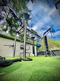 there is a large metal structure in the yard with alligators laying on the grass