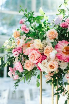 pink and white flowers are on top of gold poles