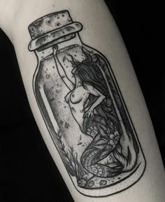 a woman in a bottle tattoo on the arm