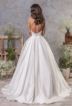 the back of a woman's wedding dress, with her hands on her hips