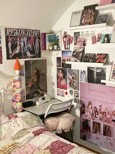 a bed room with a neatly made bed and many pictures on the wall above it