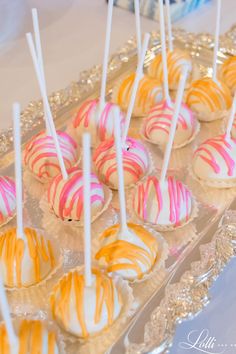 there are many candys on the tray with white and orange stripes in them,