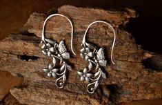 pair of silver earrings with leaves and flowers