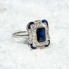 a blue and white diamond ring sitting on top of snow