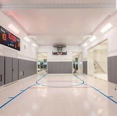 an indoor basketball court with blue and red lines on the floor, surrounded by lockers