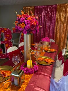 the table is set with pink and orange flowers