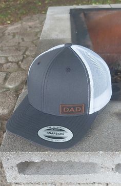 Small Classy Dad Patch in corner on Premium 6 Panel adjustable snapback structured trucker hat. Dad hat in Dark Gray Front with White Mesh Back. Adjustable snapback OSFM so one size should fit your Daddy! The perfect gift for any Dad, Fathers Day or Dad's Birthday! Give the perfect gift to your PaPa, Pops, Daddy, Paw Paw, Daddio, or really any Father would love this hat! Adjustable snap back so one size fits most! 6 Panel Structured Trucker Hat: Hat Color: Dark Gray and White Fabric: Cotton-Poly Adjustable Gray Hat For Gift, Adjustable Trucker Hat With Curved Brim For Father's Day, Father's Day Letter Print Snapback Hat With Flat Bill, Father's Day Letter Print Snapback Hat, Letter Print Snapback Hat With Curved Bill As Gift, Gift Letter Print Snapback Hat With Curved Bill, White Adjustable Baseball Cap For Father's Day, Father's Day Letter Print Adjustable Snapback Hat, Father's Day Hat With Letter Print And Curved Bill